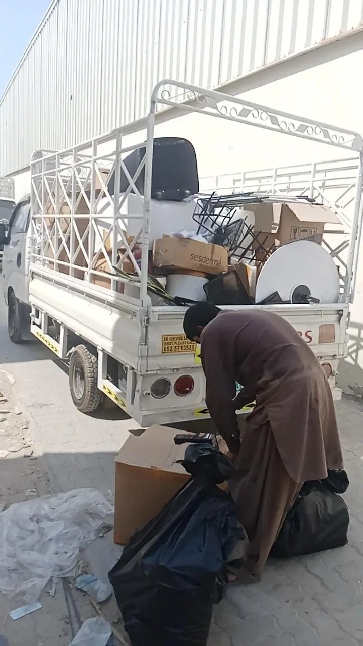 Crew packing old furniture onto a pickup truck in Dubai